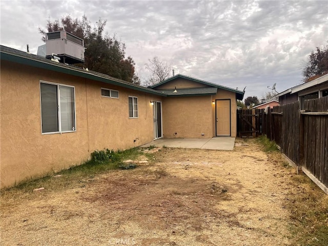 rear view of house with a patio and central AC