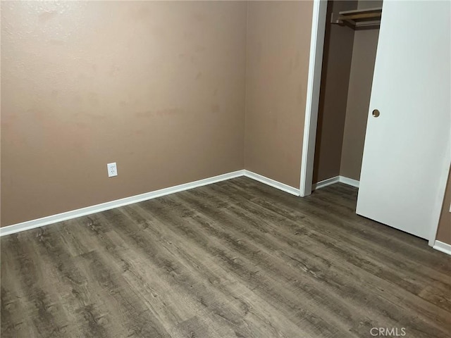 unfurnished bedroom featuring dark wood-type flooring and a closet