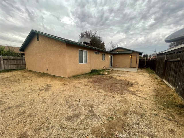 rear view of property with central AC and a patio area