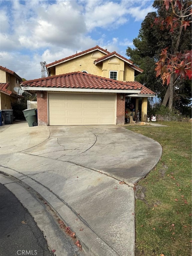 mediterranean / spanish-style house featuring a front yard and a garage