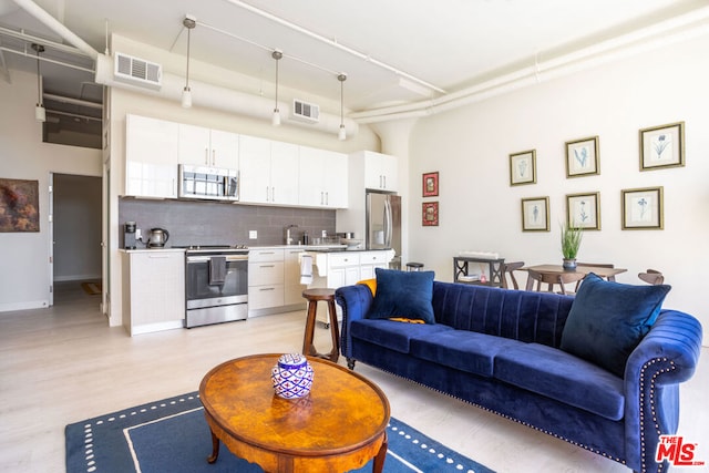 living room featuring a high ceiling and light hardwood / wood-style flooring