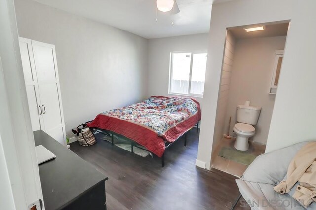 bedroom with ceiling fan, ensuite bath, and dark hardwood / wood-style floors