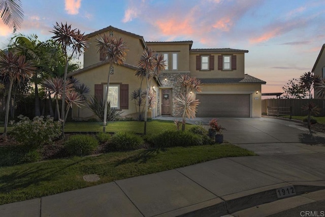 mediterranean / spanish-style home with a garage and a lawn