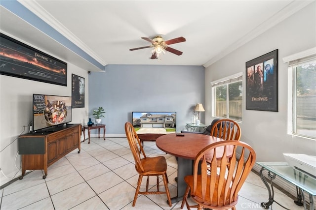 tiled dining space featuring ceiling fan and crown molding