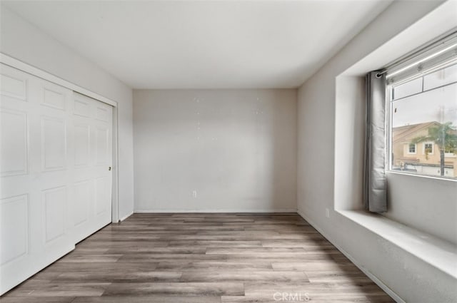 unfurnished bedroom with a closet and light hardwood / wood-style flooring