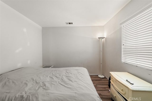 bedroom with dark wood-type flooring