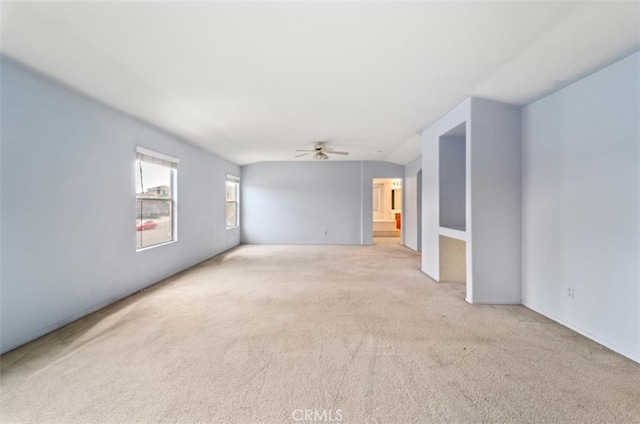 empty room with ceiling fan, light carpet, and vaulted ceiling