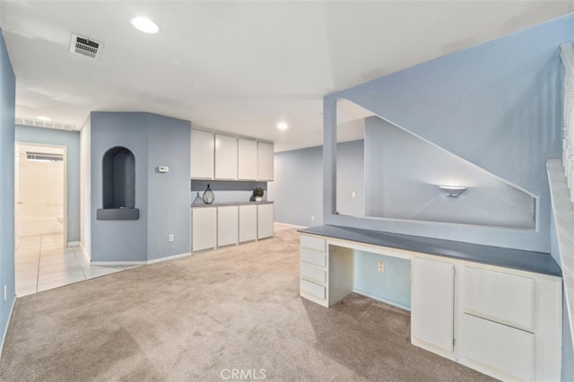 interior space featuring light carpet and white cabinetry