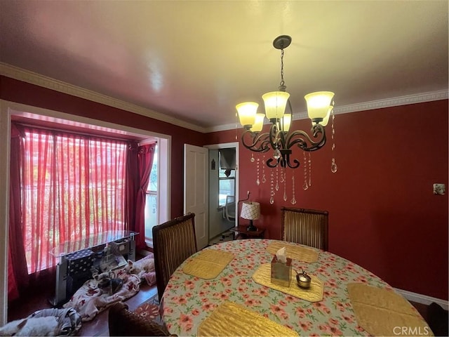 dining space featuring a notable chandelier and crown molding