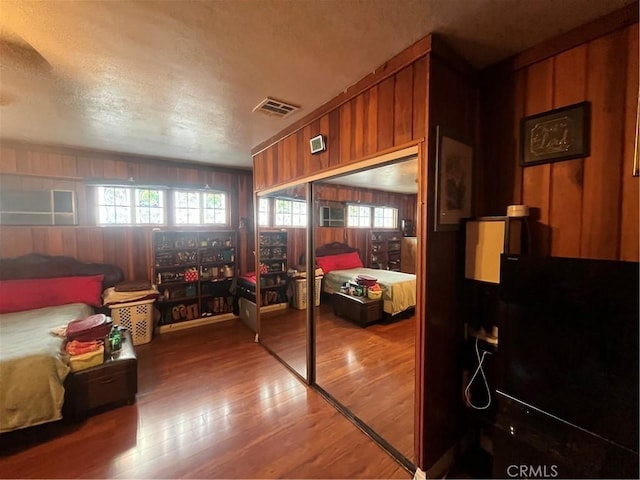 bedroom featuring hardwood / wood-style floors and wood walls