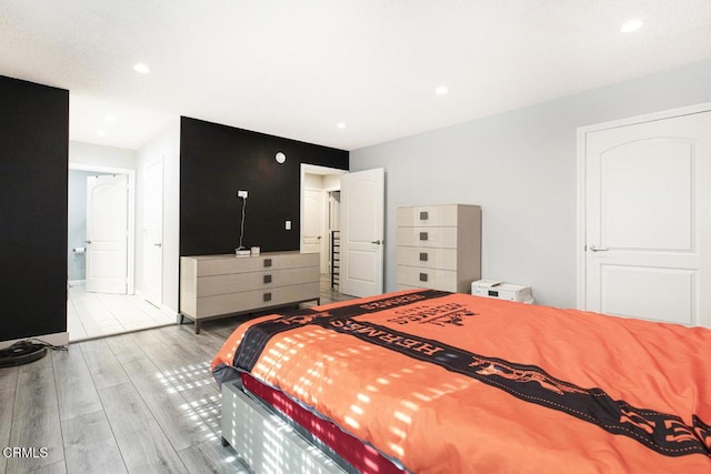 bedroom featuring ensuite bath and light wood-type flooring