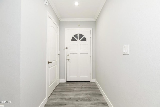 doorway with light hardwood / wood-style flooring and crown molding