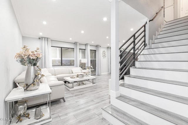 living room with light wood-type flooring and crown molding