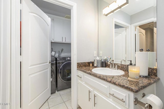 bathroom with washing machine and clothes dryer, tile patterned floors, and vanity