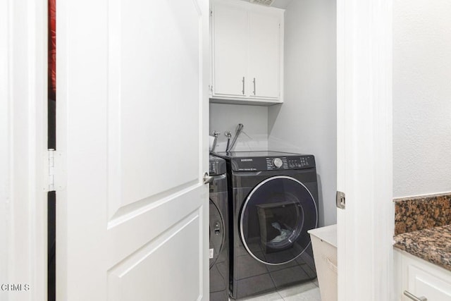 laundry area with cabinets, independent washer and dryer, and light tile patterned floors