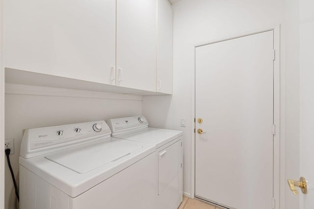 laundry room featuring cabinets and washing machine and dryer