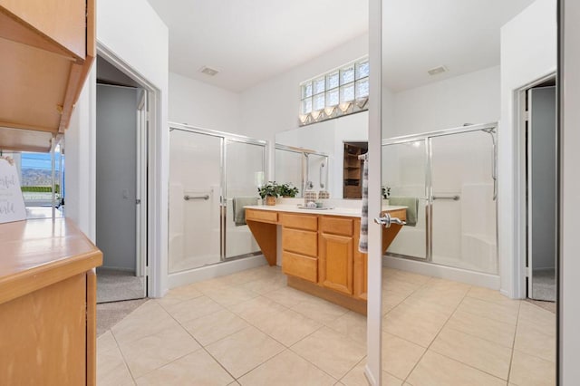 bathroom with a shower with door, tile patterned floors, and plenty of natural light