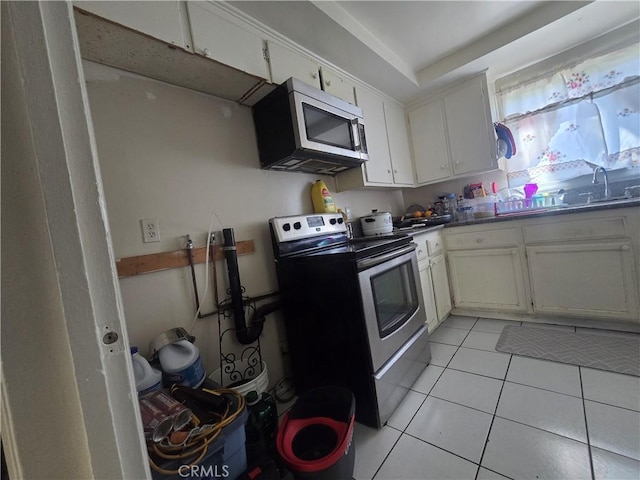 kitchen featuring white cabinetry, appliances with stainless steel finishes, sink, and light tile patterned floors