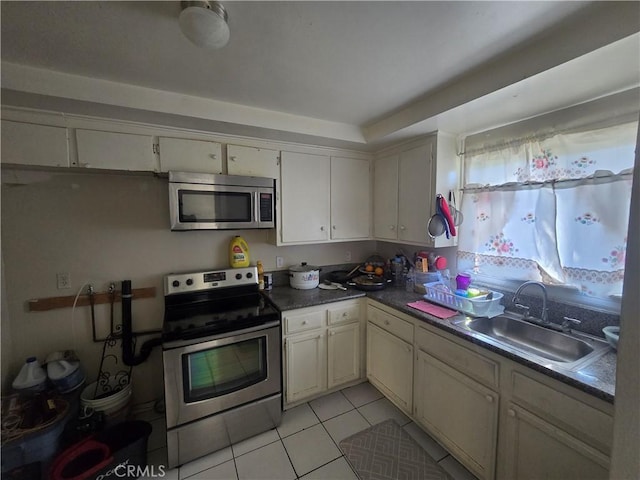 kitchen with appliances with stainless steel finishes, sink, and light tile patterned floors