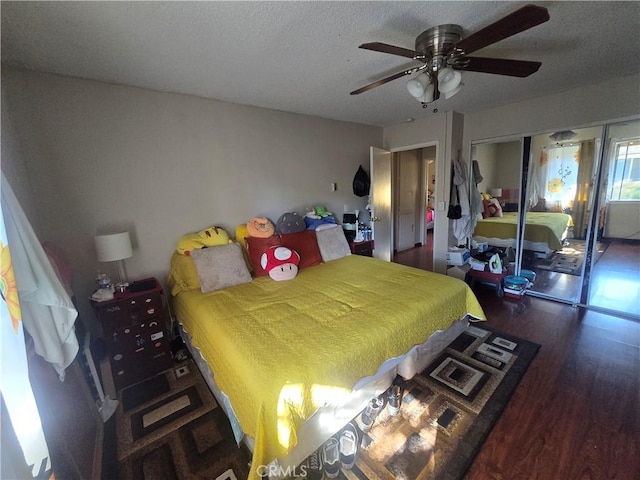 bedroom with dark hardwood / wood-style flooring, a textured ceiling, ceiling fan, and a closet