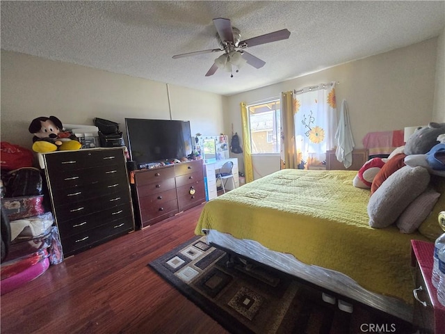 bedroom with ceiling fan, dark hardwood / wood-style flooring, and a textured ceiling