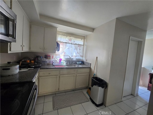 kitchen featuring sink, range with electric stovetop, and light tile patterned flooring