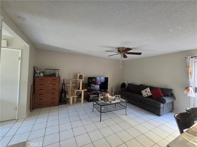 tiled living room featuring ceiling fan and a textured ceiling