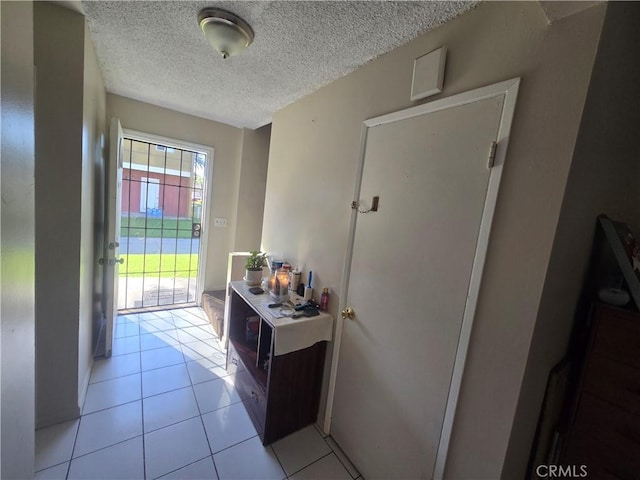 entryway featuring light tile patterned floors and a textured ceiling