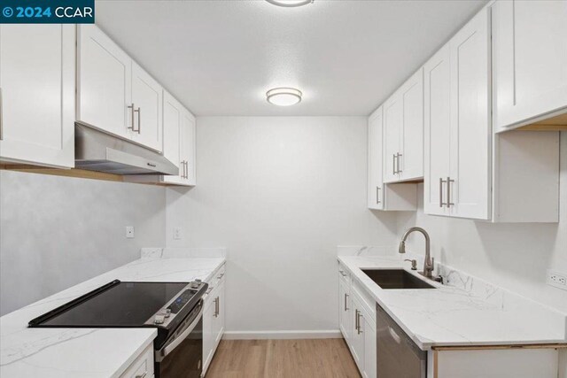 kitchen featuring white cabinetry, sink, stainless steel appliances, and light wood-type flooring