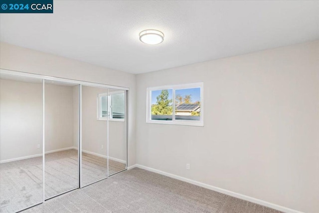 unfurnished bedroom featuring a closet and carpet floors