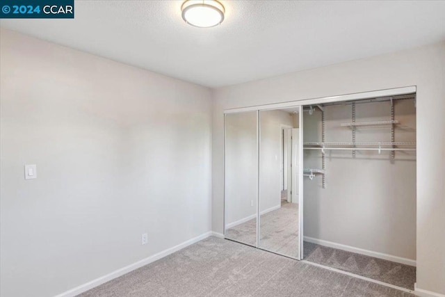 unfurnished bedroom featuring carpet floors and a closet