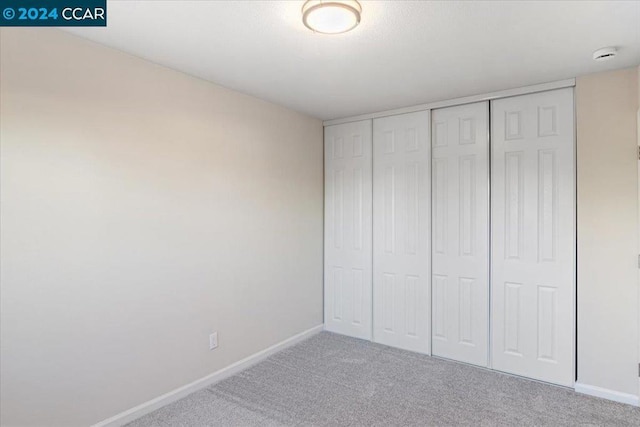 unfurnished bedroom featuring carpet and a closet