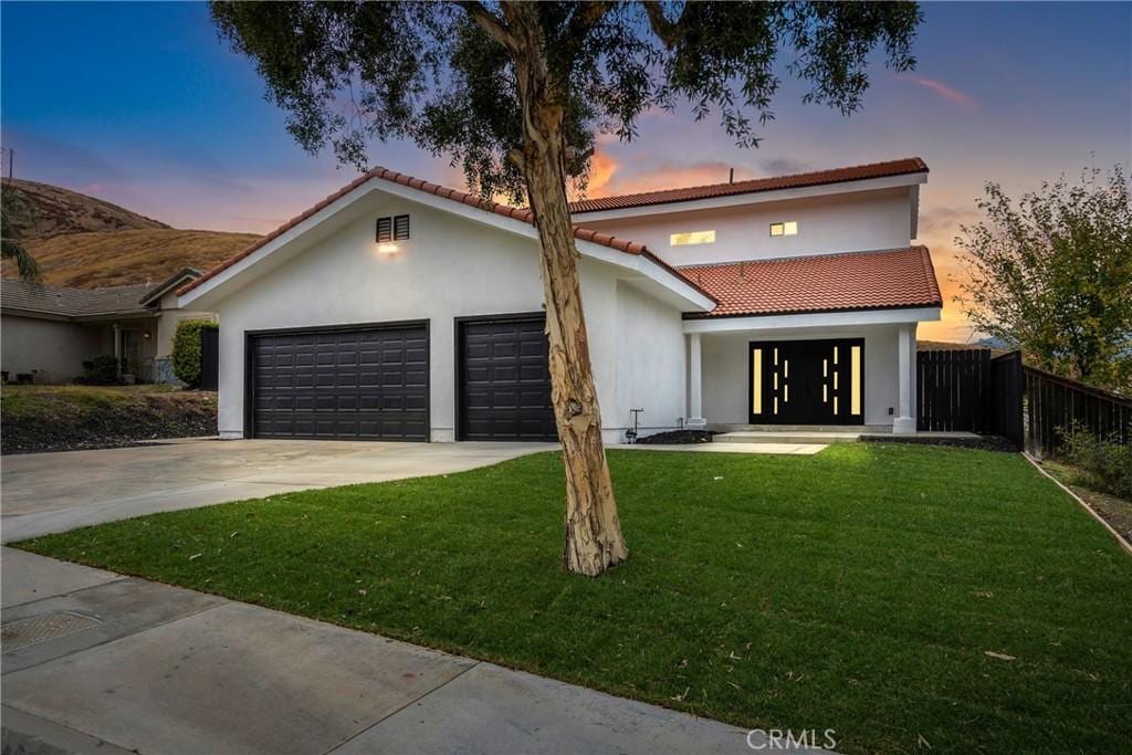 view of front facade with a garage and a lawn