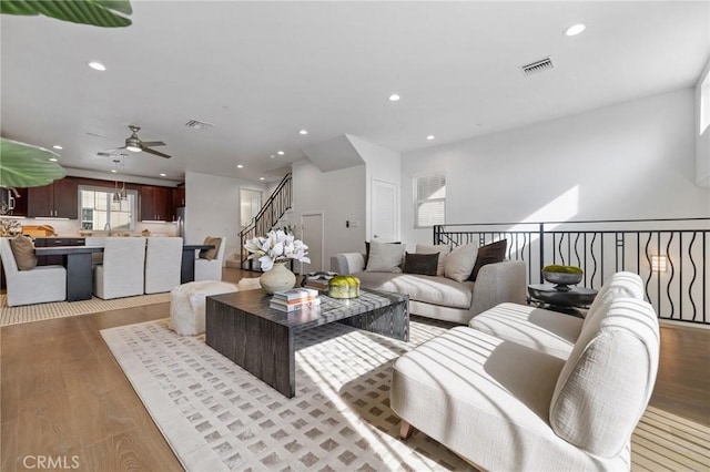 living room featuring ceiling fan, light hardwood / wood-style floors, and sink