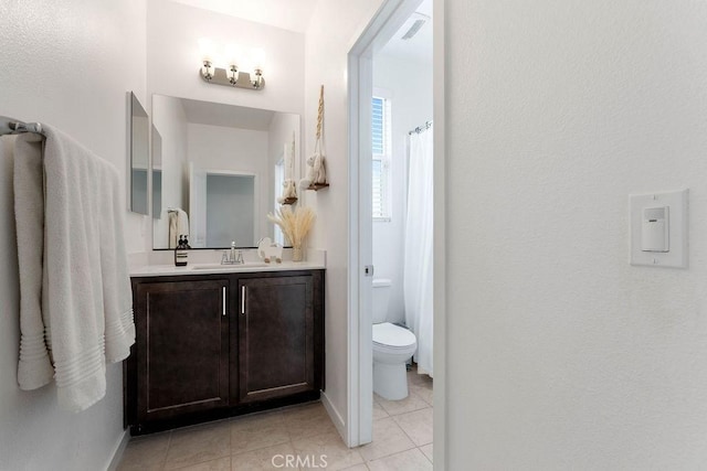 bathroom with tile patterned flooring, vanity, and toilet