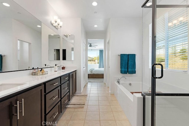 bathroom featuring tile patterned floors, vanity, ceiling fan, and tiled tub