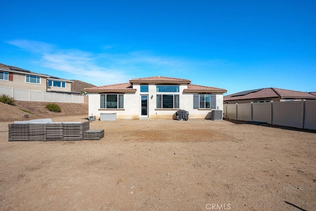 rear view of house with central AC unit and an outdoor living space