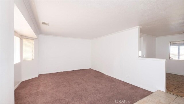 empty room featuring ornamental molding and carpet flooring