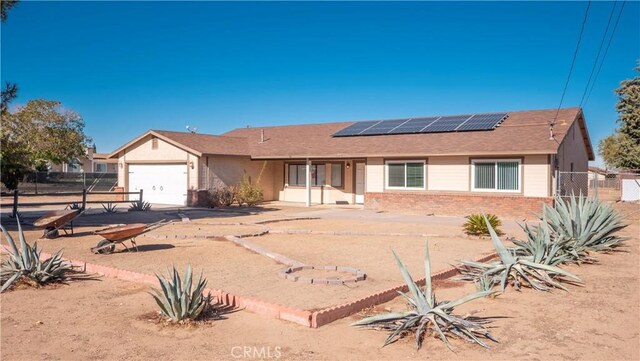 single story home with solar panels and a garage