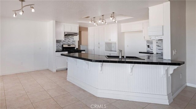 kitchen with white cabinetry, tile countertops, kitchen peninsula, and a kitchen bar