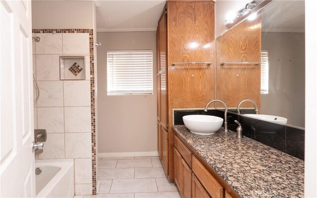 bathroom with vanity, tile patterned floors, ornamental molding, and tiled shower / bath