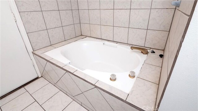 bathroom with tile patterned floors and tiled bath