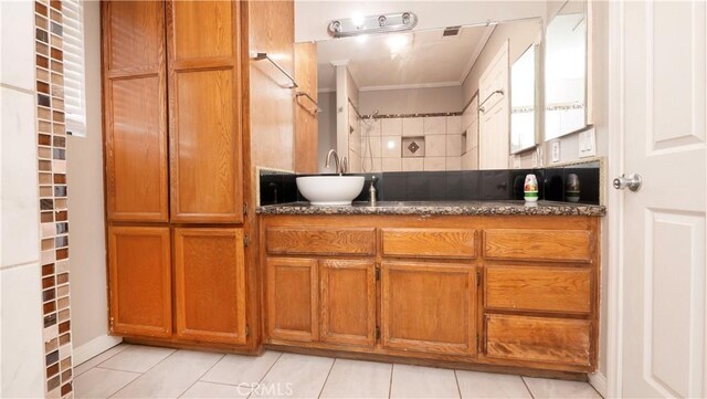 bathroom featuring tile patterned flooring, vanity, and ornamental molding