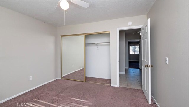 unfurnished bedroom with carpet flooring, a textured ceiling, ceiling fan, and a closet