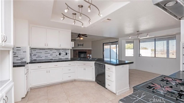 kitchen with black appliances, kitchen peninsula, a raised ceiling, ceiling fan, and white cabinets