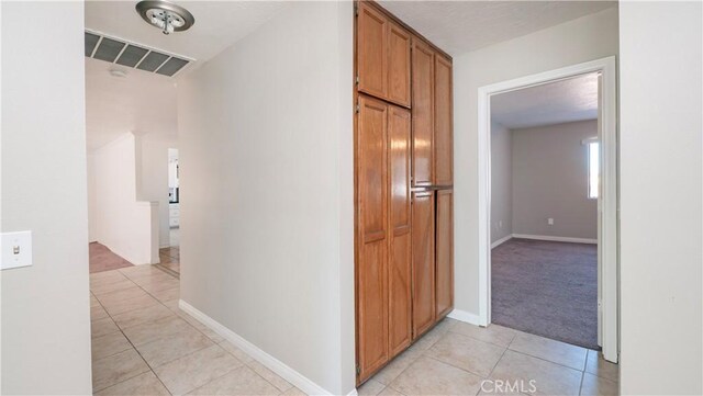 hall with light tile patterned floors