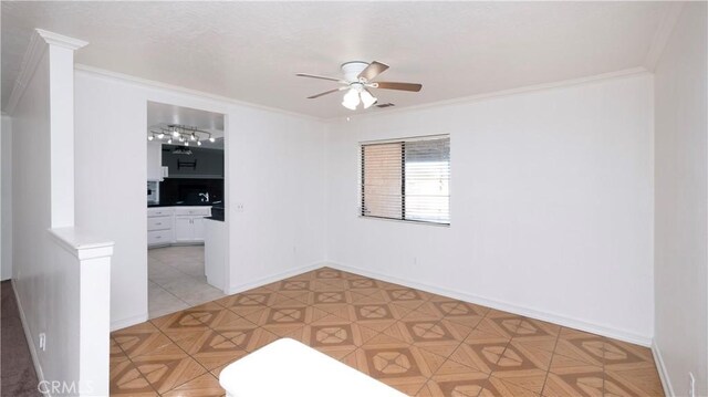 spare room featuring tile patterned flooring, ornamental molding, and ceiling fan