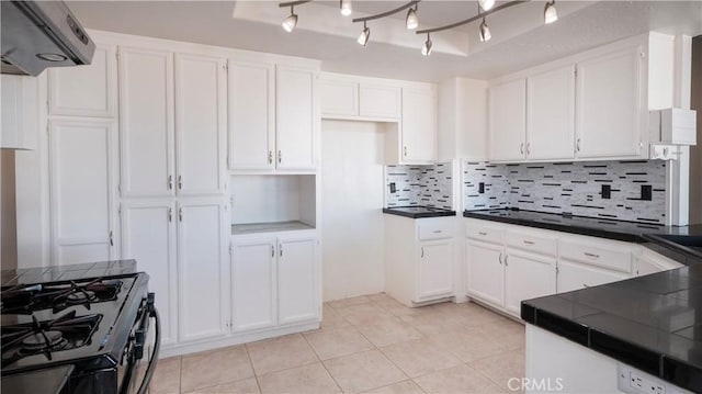 kitchen featuring white cabinetry, tasteful backsplash, light tile patterned floors, tile counters, and range with gas stovetop