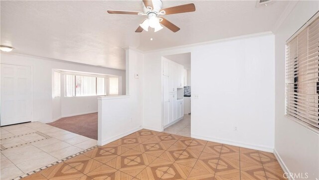 empty room featuring crown molding and ceiling fan