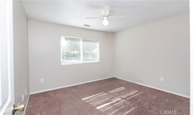 carpeted spare room featuring ceiling fan